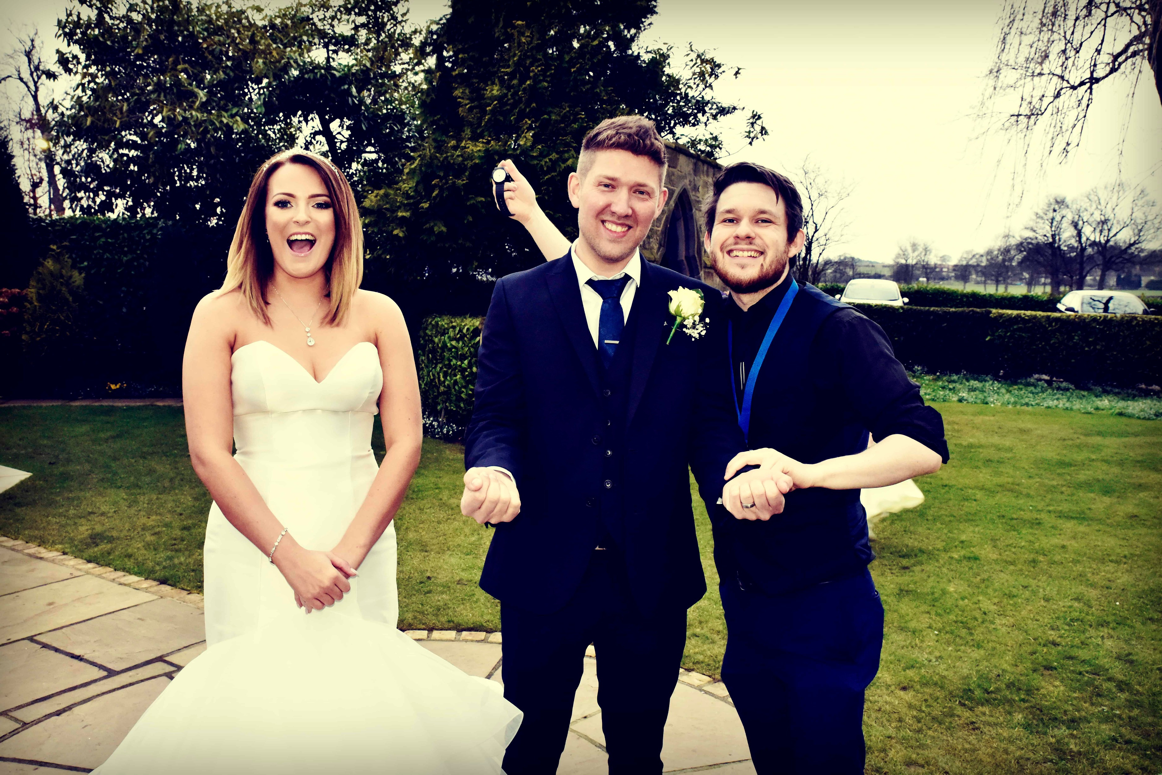Wedding magician Greg Holroyd with a laughing bride and groom moments after a close-up magic reveal during their big day. Pure reactions, pure connection, no stage—just real magic.